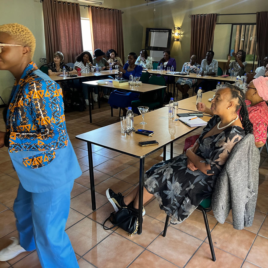 People seated around tables during a facilitated conference session.