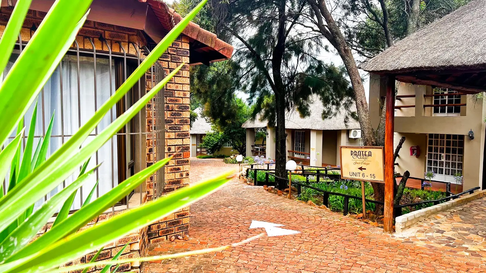 The Protea Ridge entrance sign beside the brick reception buildings.