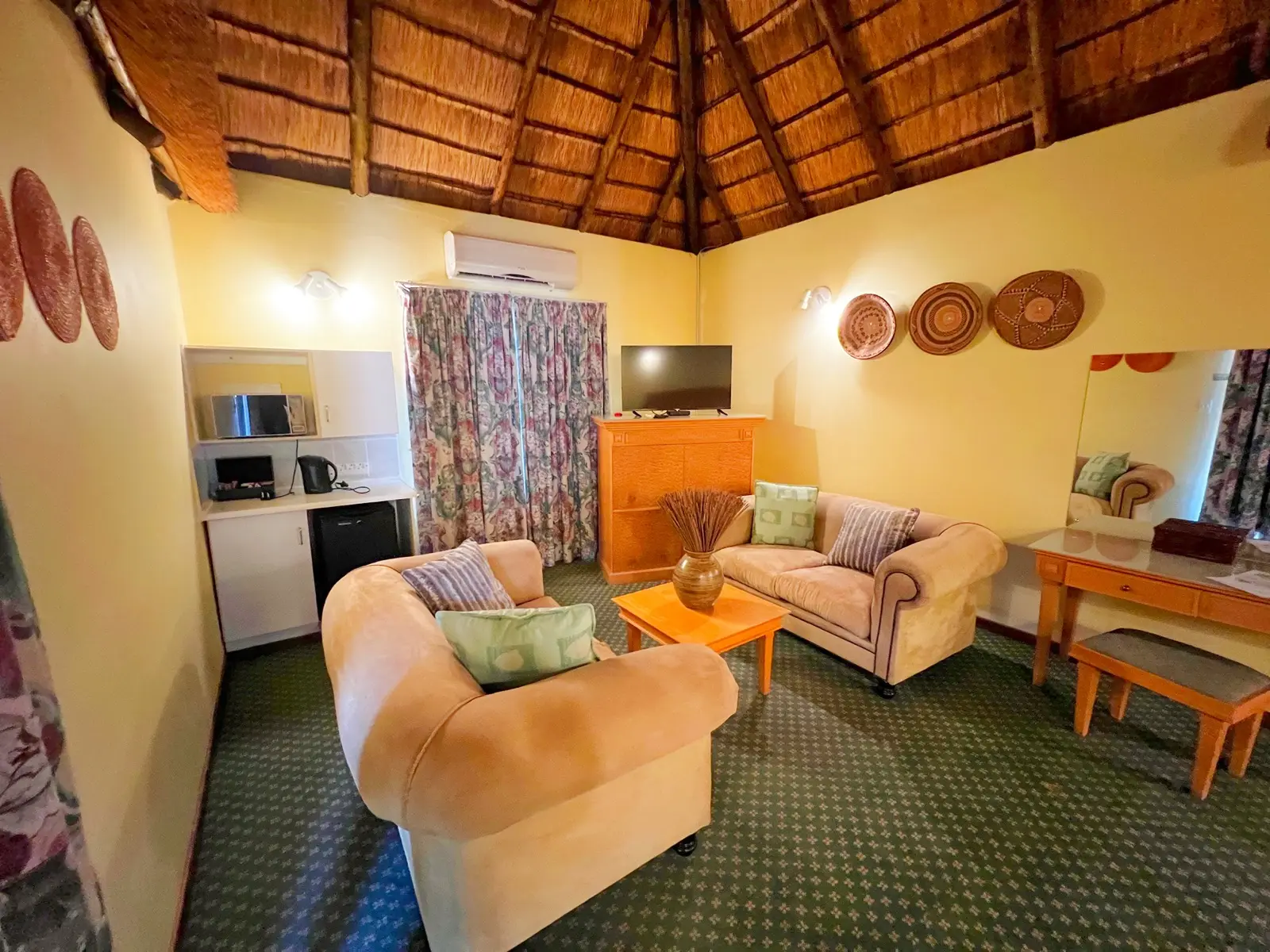 An open-plan suite lounge with kitchenette and seating.
