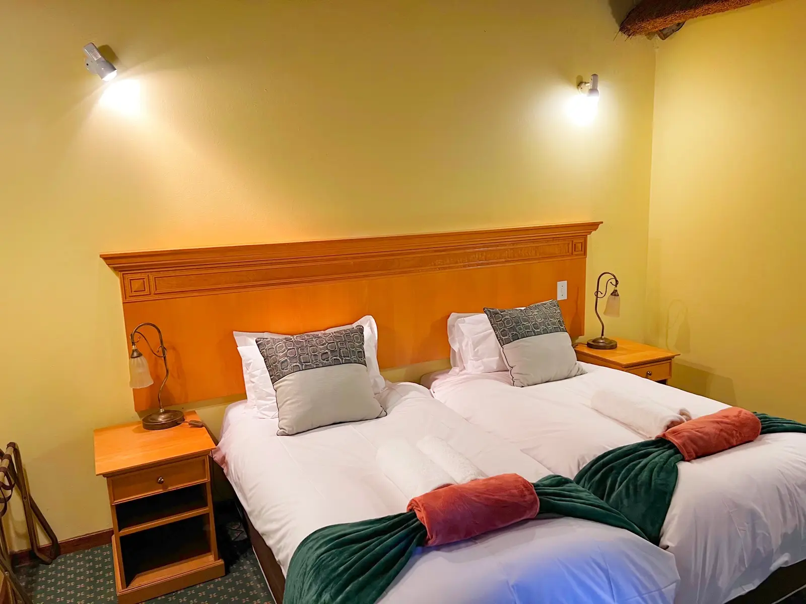 A suite bedroom with a double bed and timber headboard.
