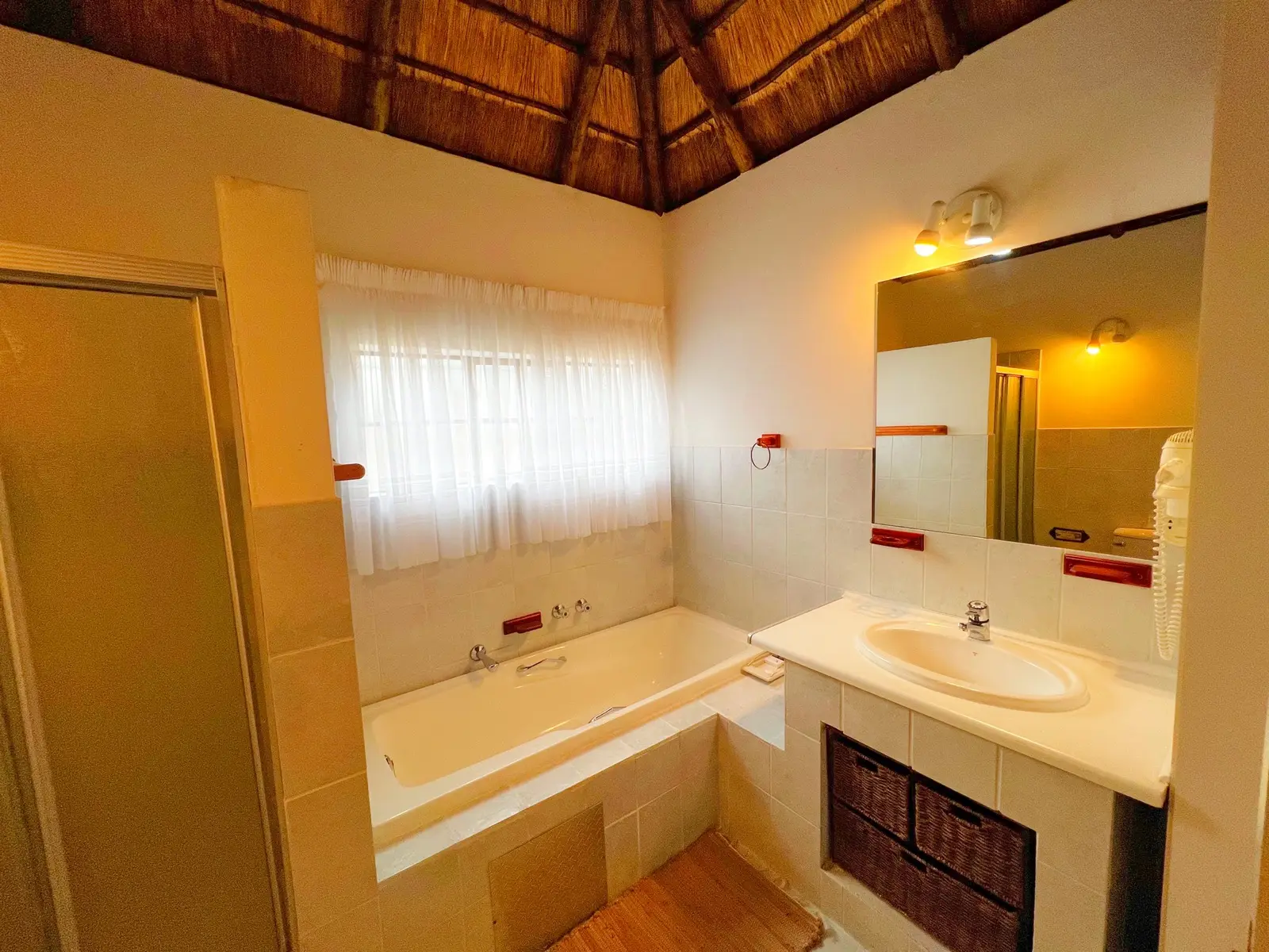 A bathroom with a bath, shower and vanity basin.