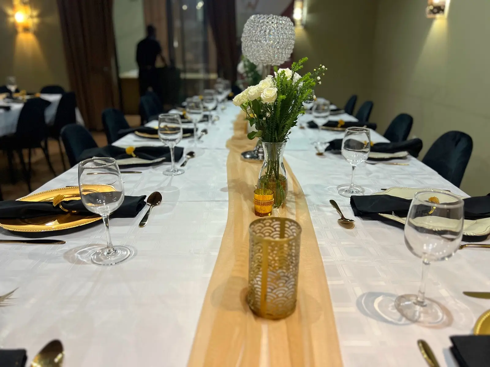 A formal dining table dressed with linen, glassware and fresh flowers.