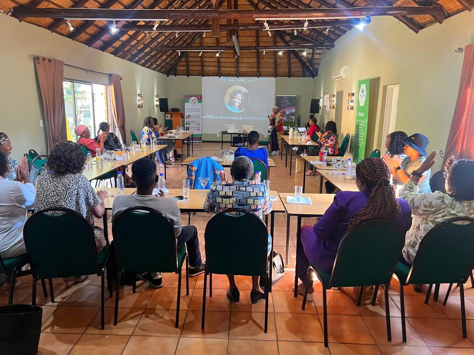 Delegates seated for a presentation in the thatched conference hall.