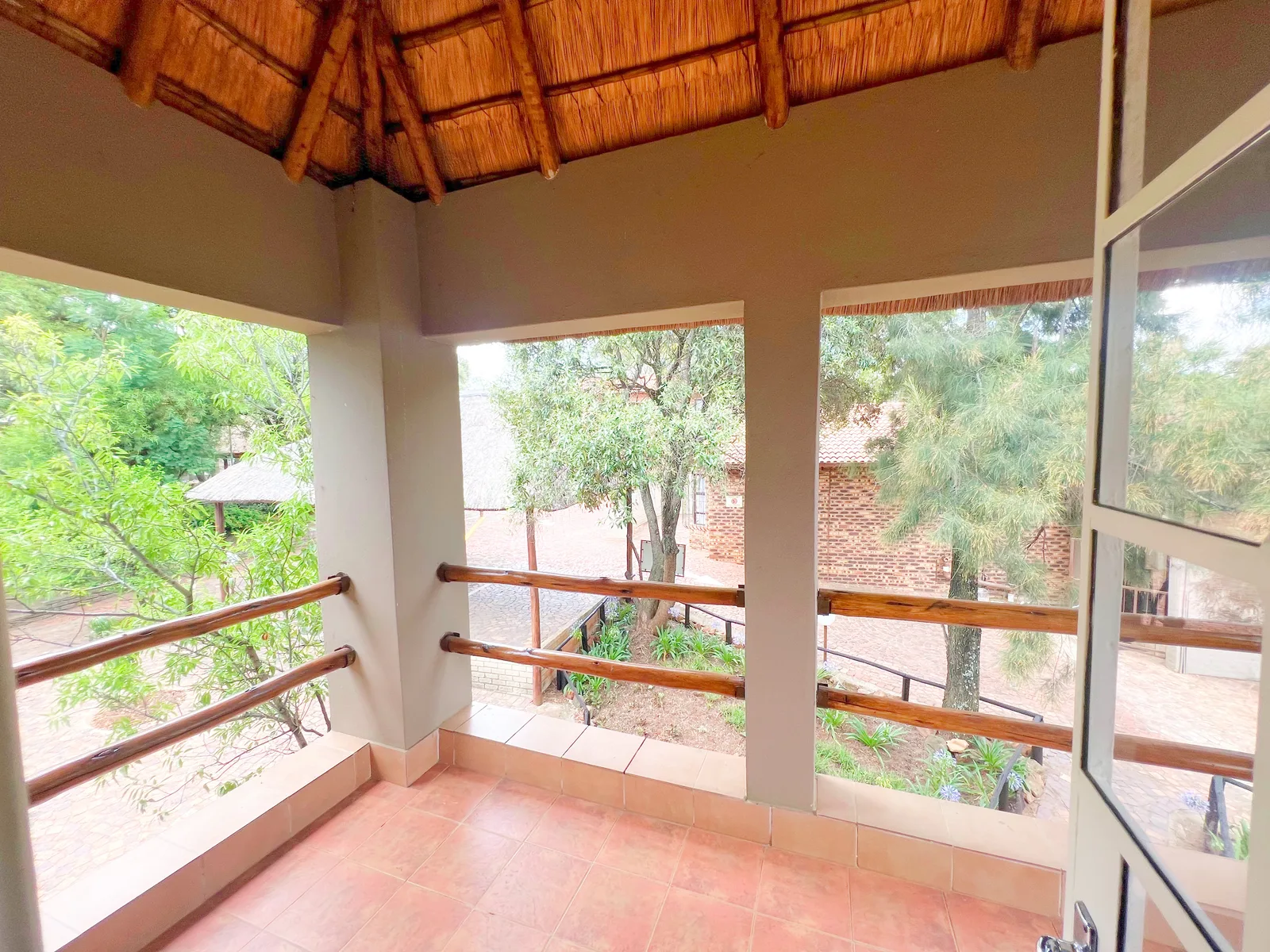 A covered cottage balcony overlooking the gardens.