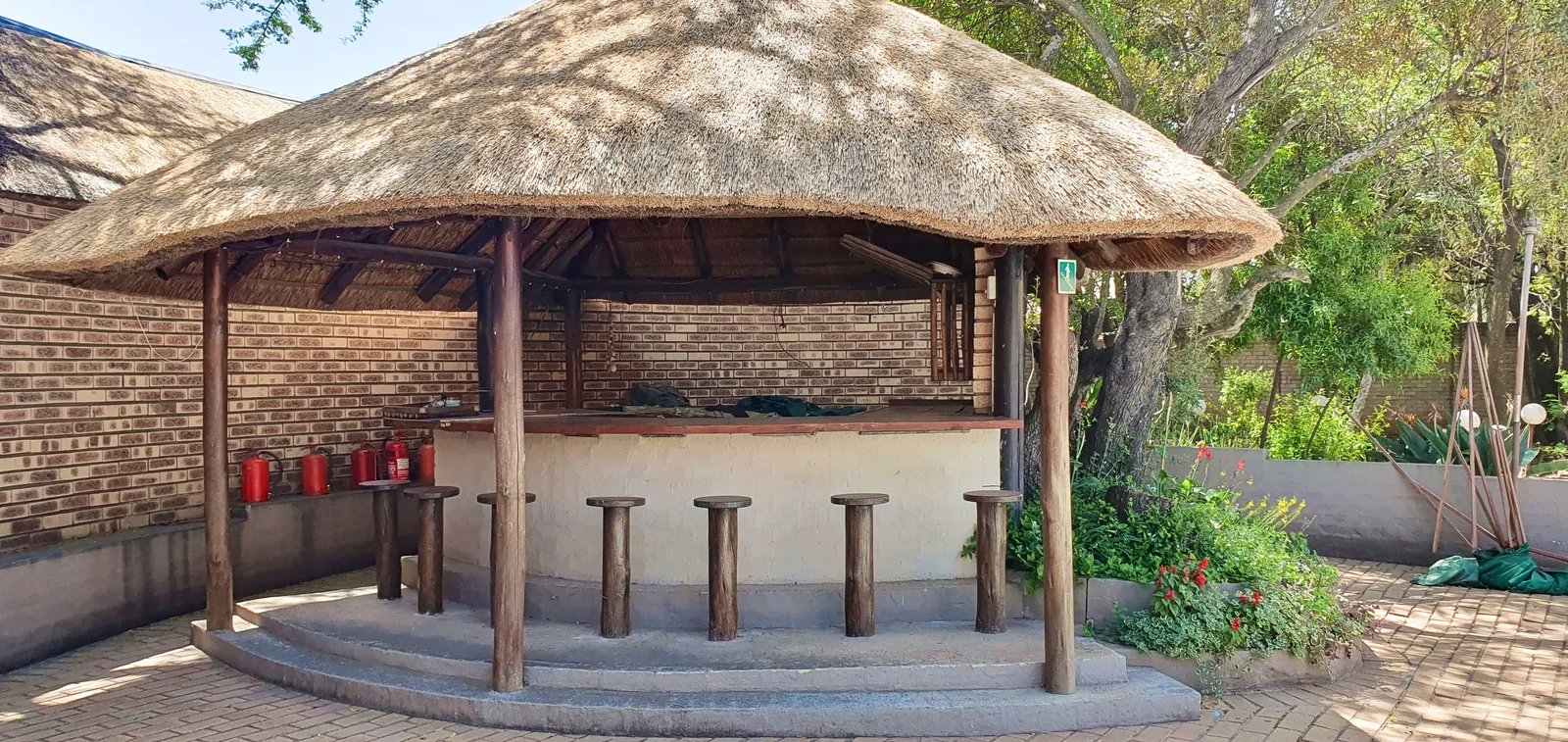 An outdoor bar beneath the thatched lapa.