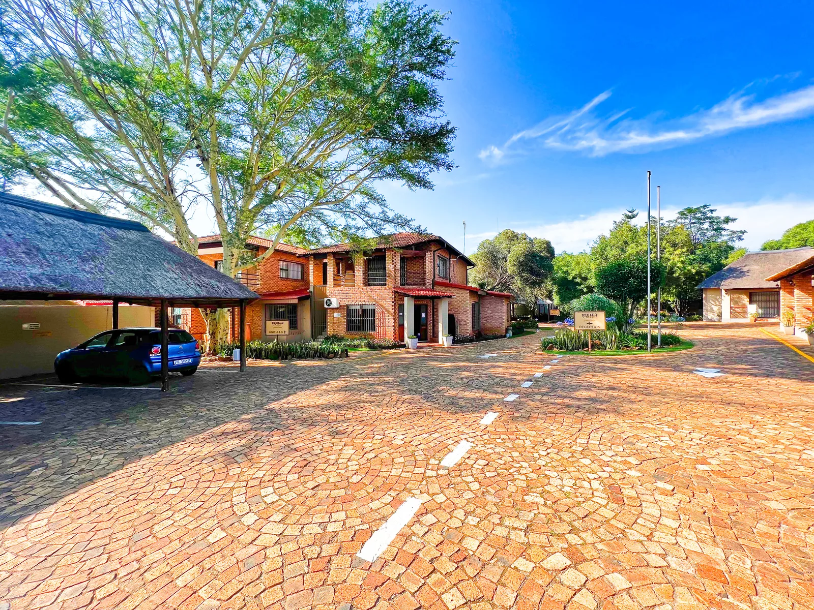 The paved arrival area and brick buildings at Protea Ridge.